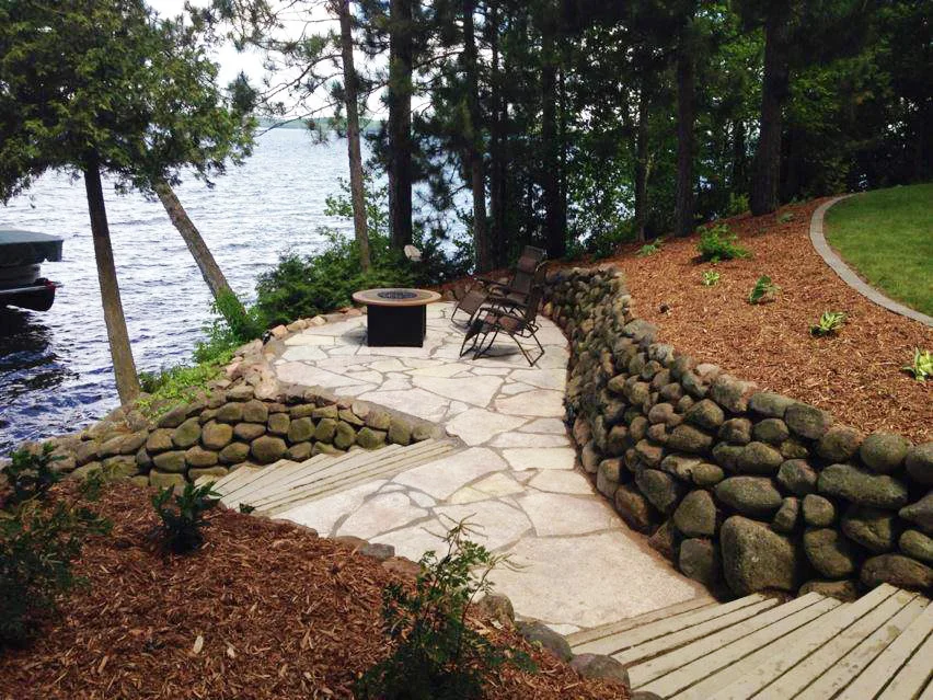 Stone-walled fire pit terrace beside a lake
